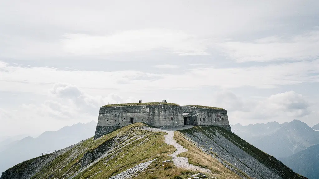Un fort en pierre sur une crête alpine balayée par le vent, dominé par un ciel immense, montrant l'isolement d'une fortification d'altitude sans aucun texte visible.